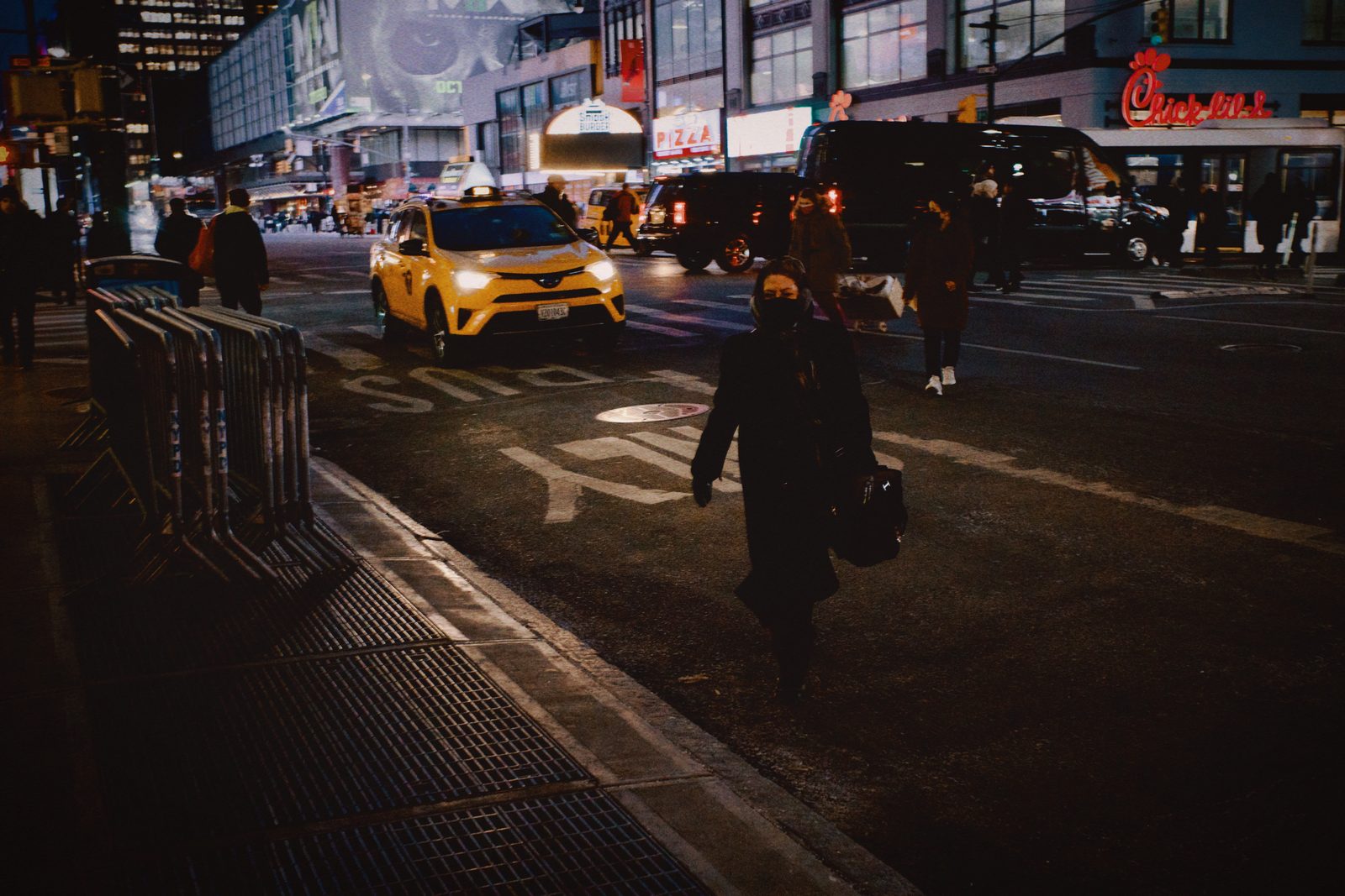 A man standing on a night street, city lights behind him — New York