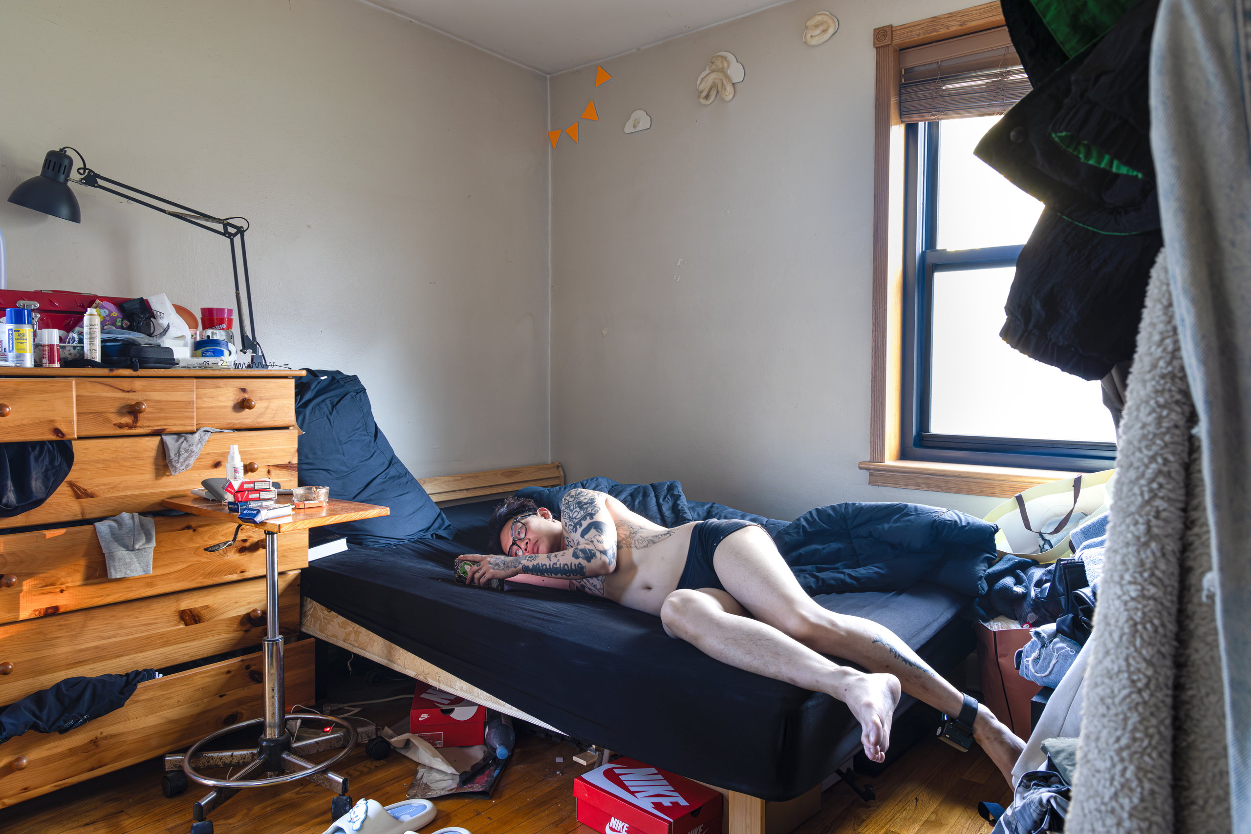 A small bedroom with wooden bunk beds, a figure resting on the lower bed in window light — Win or Lose