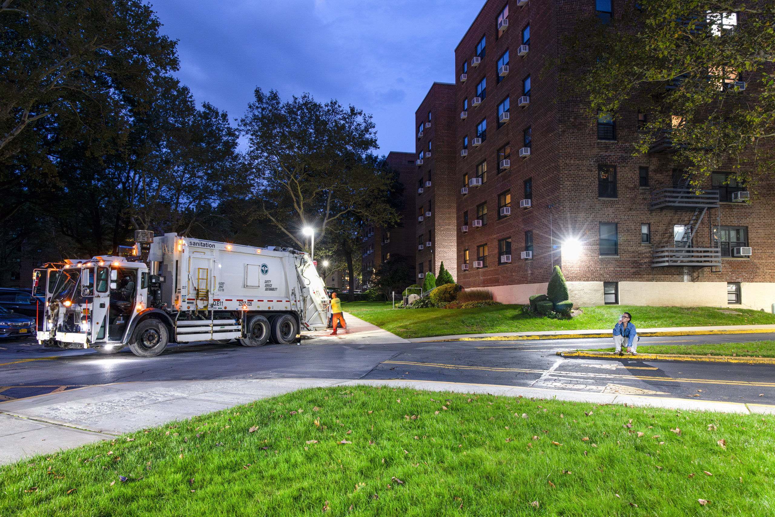 Apartment blocks at dusk, a garbage truck on the street below — Win or Lose