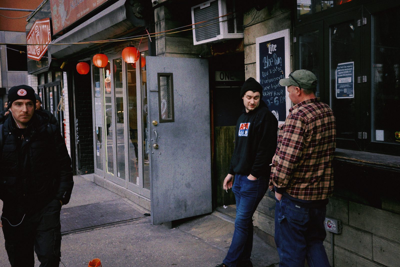 A night street corner with lit shopfronts — New York